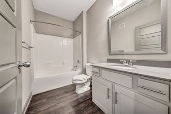 A bathroom with a toilet, sink, and shower.